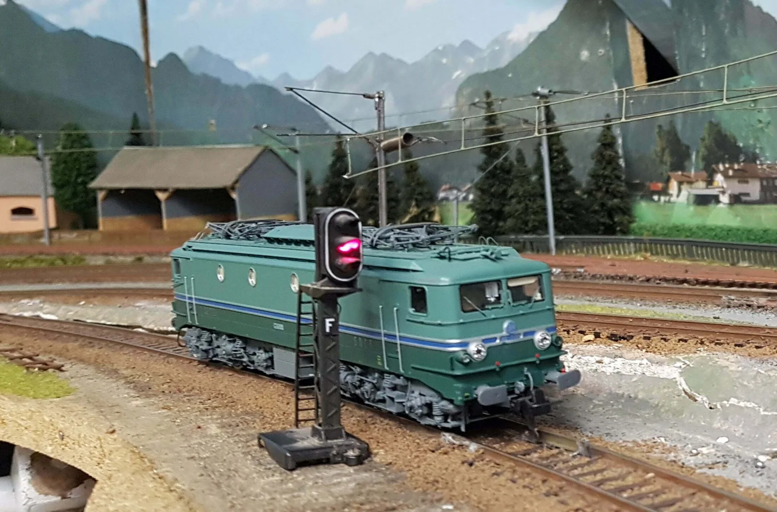 Locomotive miniature devant un signal ferroviaire